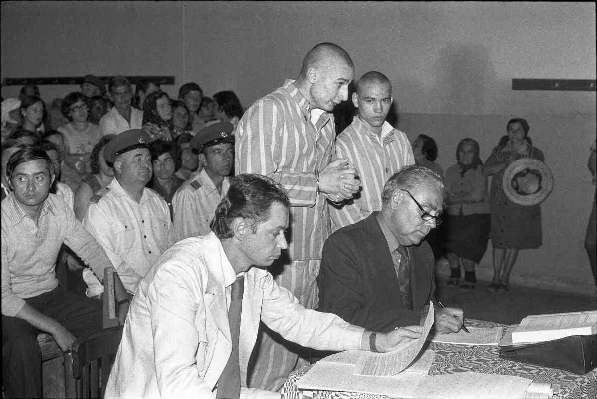 Men in prison uniforms at a court hearing