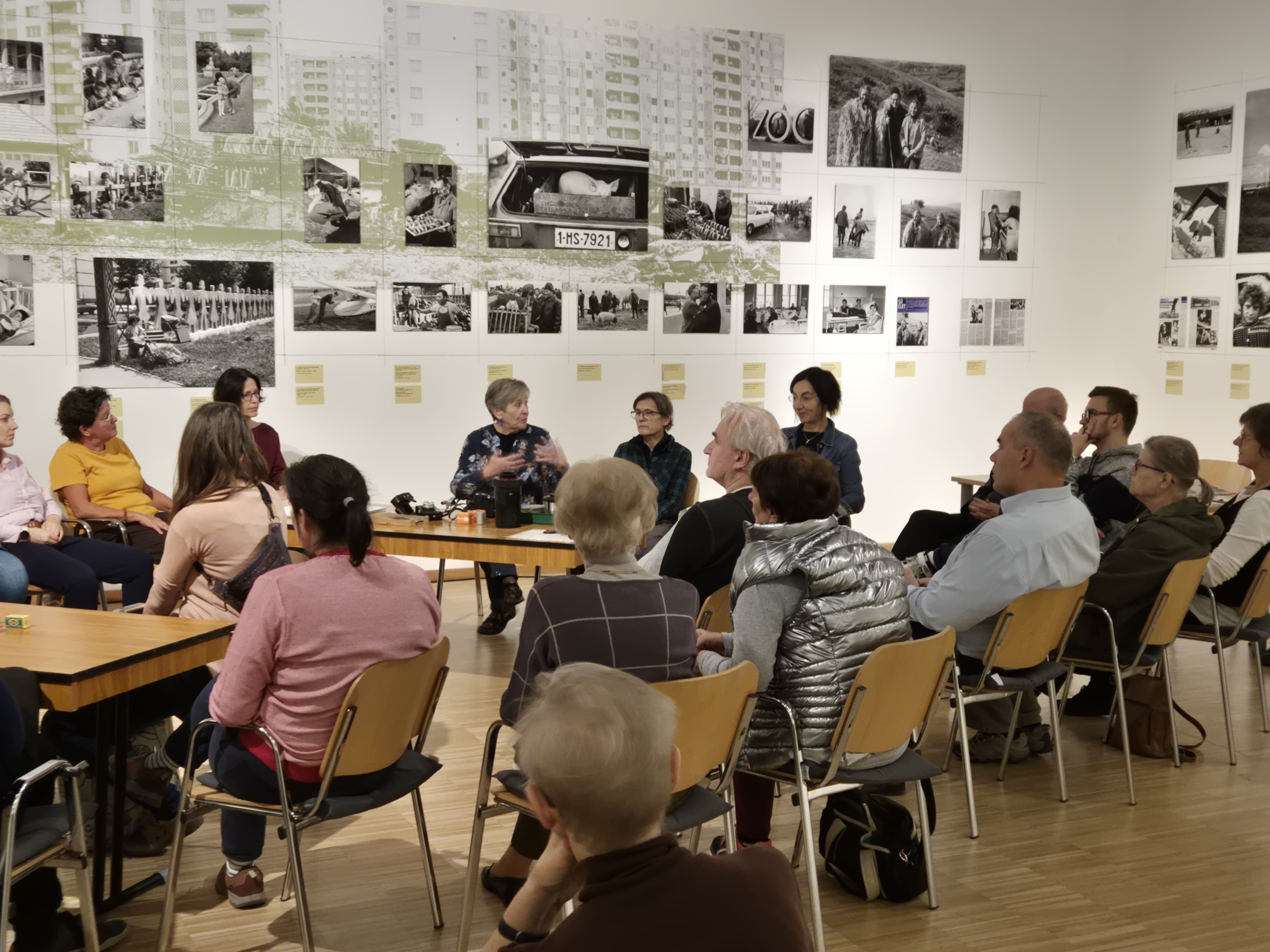 A pig in an old-fashioned cart, with people standing around it