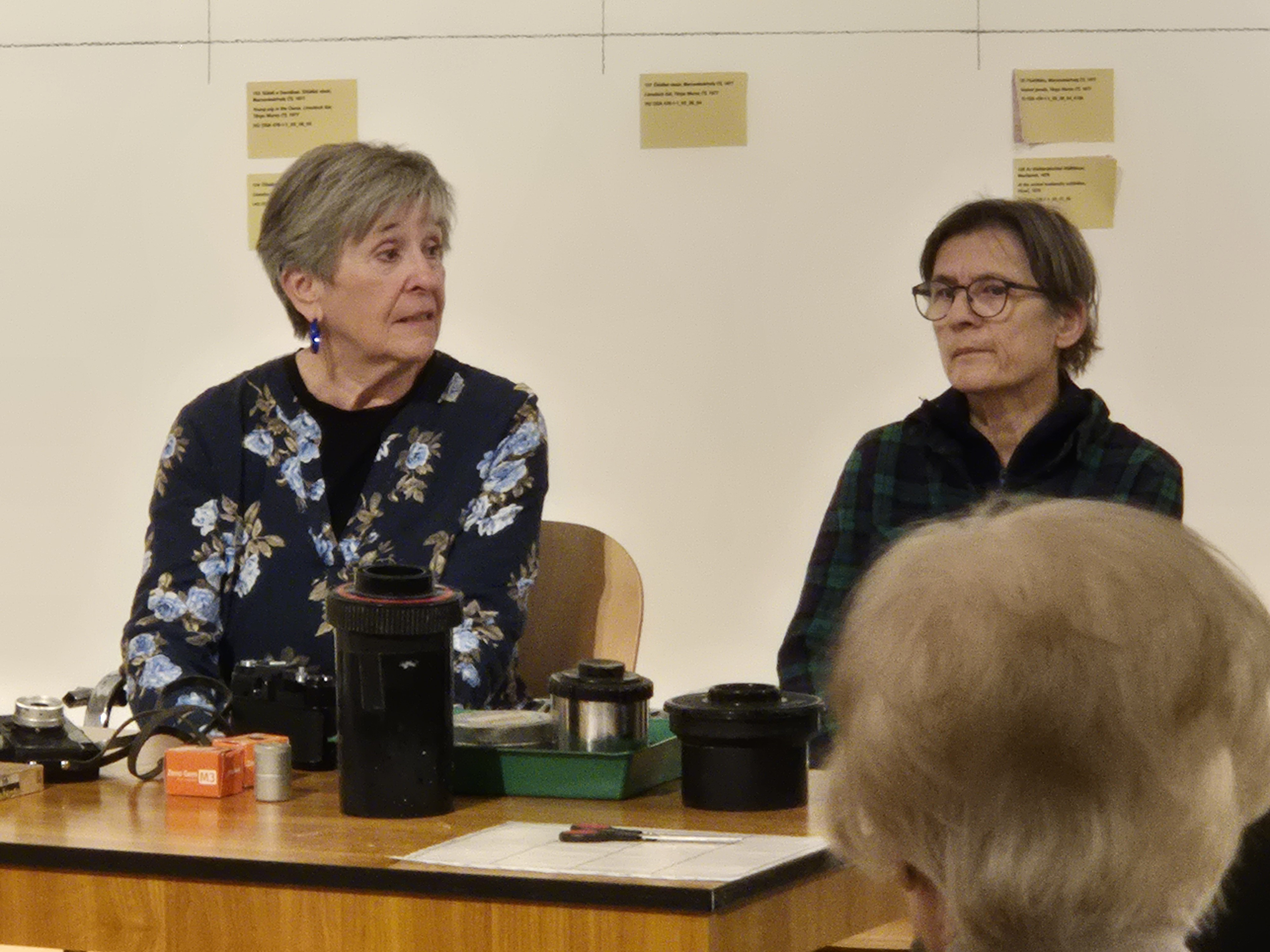A pig in an old-fashioned cart, with people standing around it