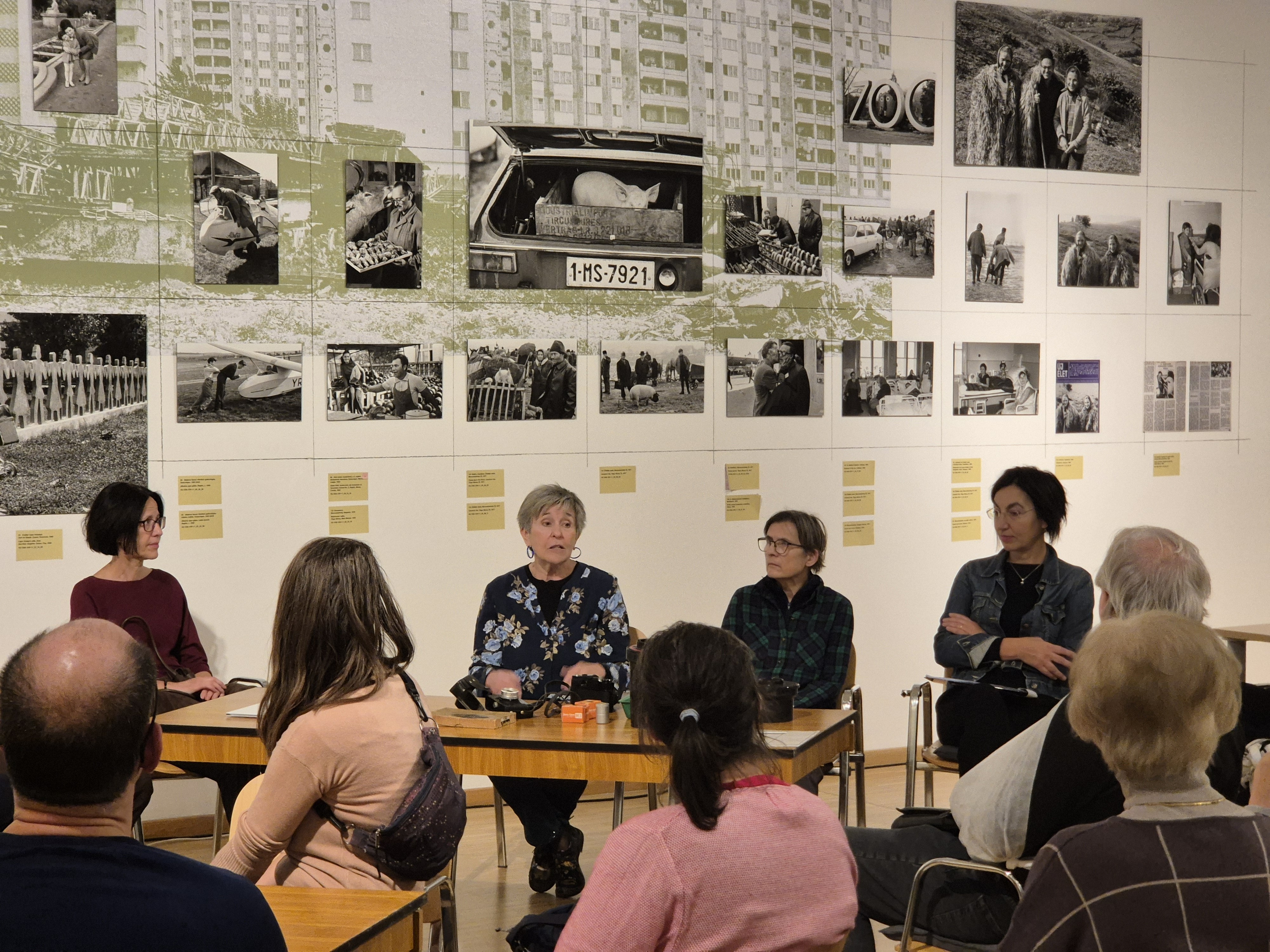A pig in an old-fashioned cart, with people standing around it
